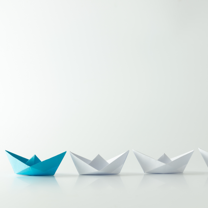 three boats, the front one is blue and leading the other white coloured boats