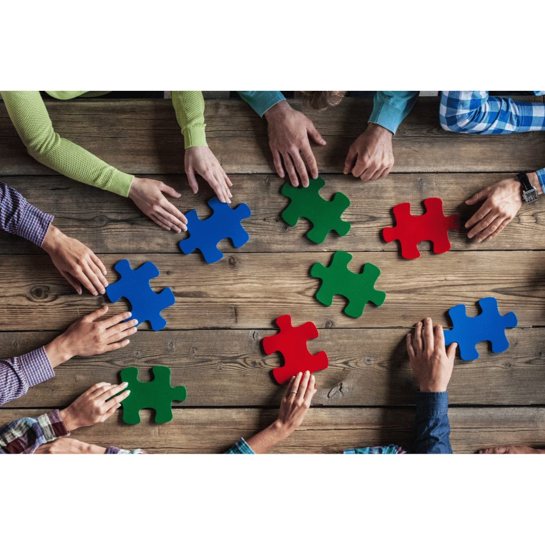 photo of team working together to put coloured puzzle pieces in a pattern on a table